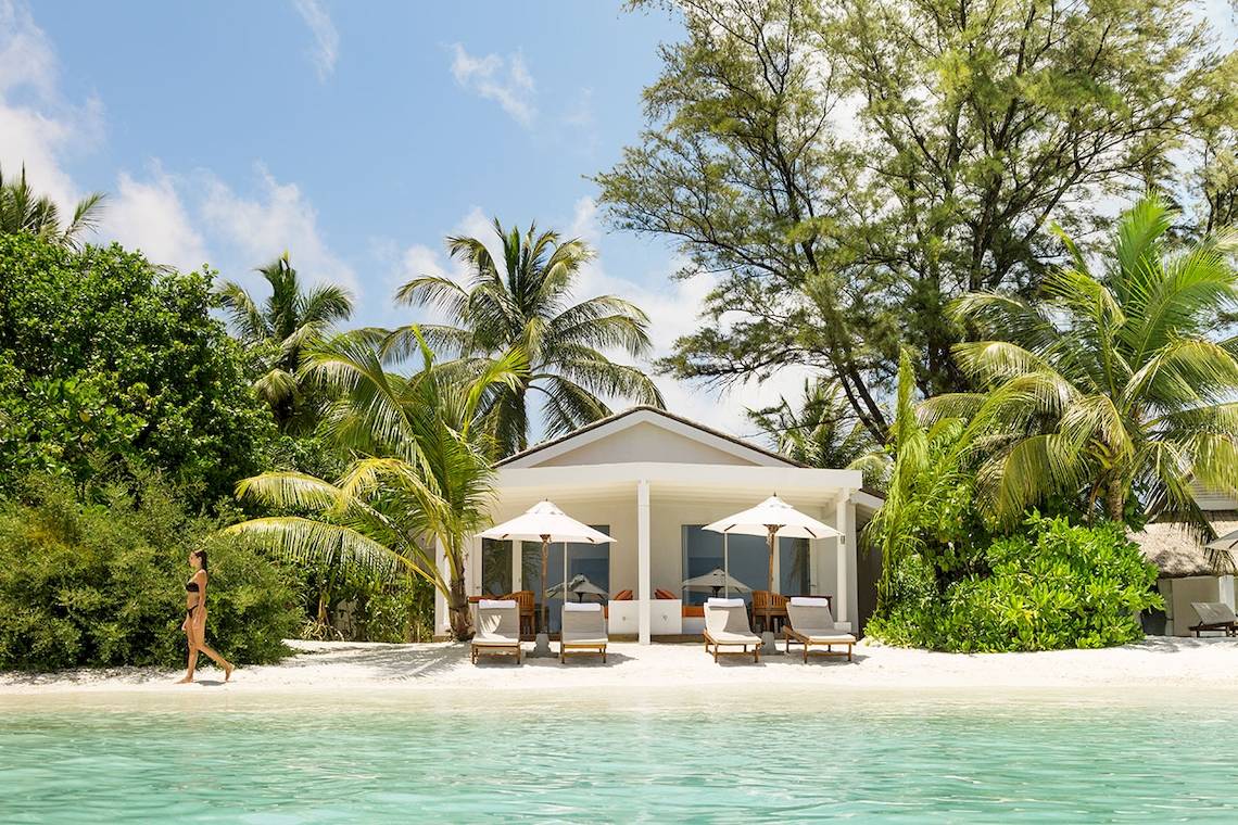 Villa am Strand des LUX South Ari Atoll Hotels mit Frau und Palmen