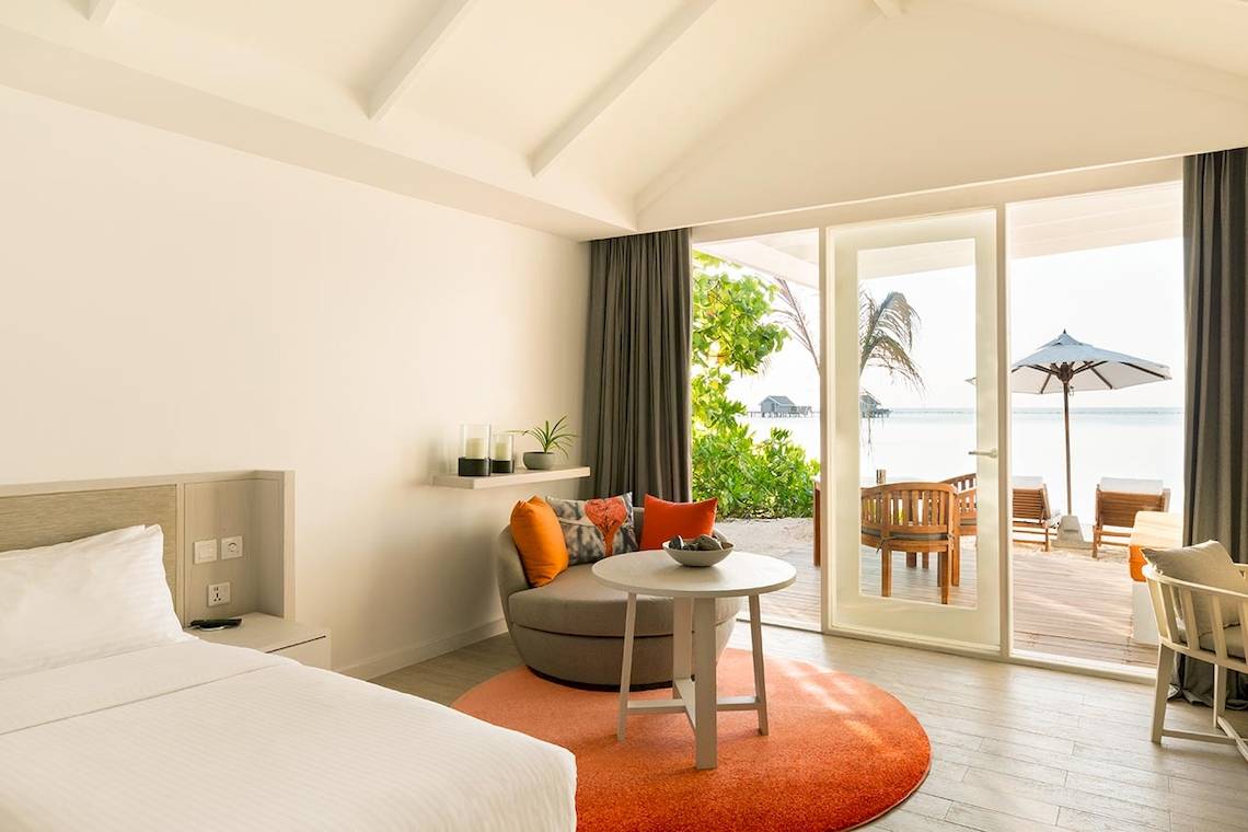 Luxuriöses Zimmer im LUX South Ari Atoll Hotel mit Meerblick, offener Terrasse und modernen Möbeln.