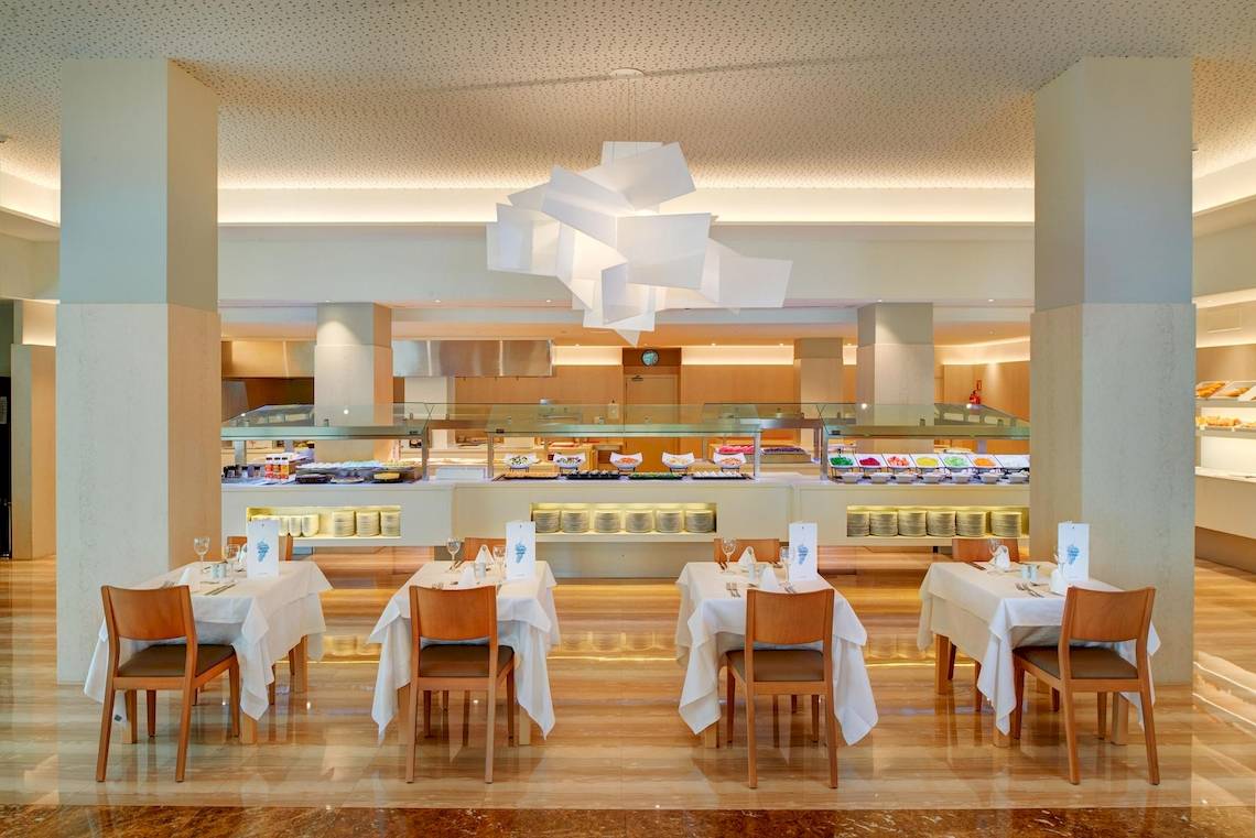 Innenbereich des Restaurants im Hipotels Said Hotel mit weißen Tischen und Stühlen.