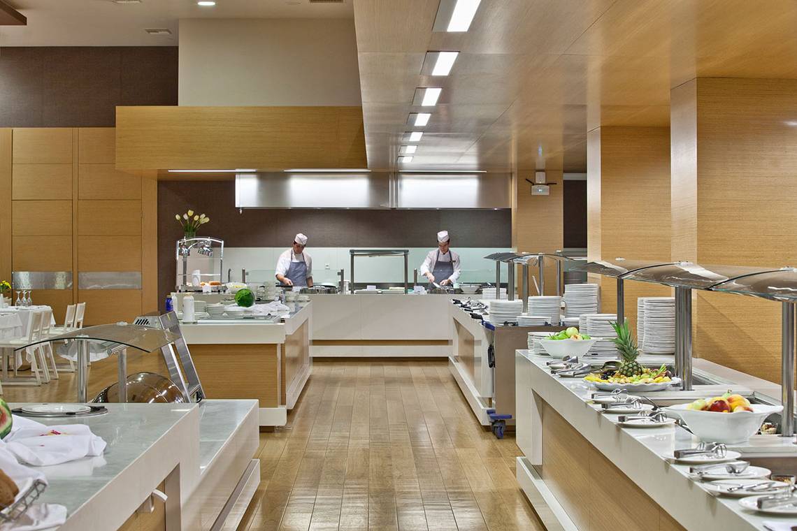 Buffetbereich im Avra Imperial Hotel mit Köchen, die Essen zubereiten und servieren.