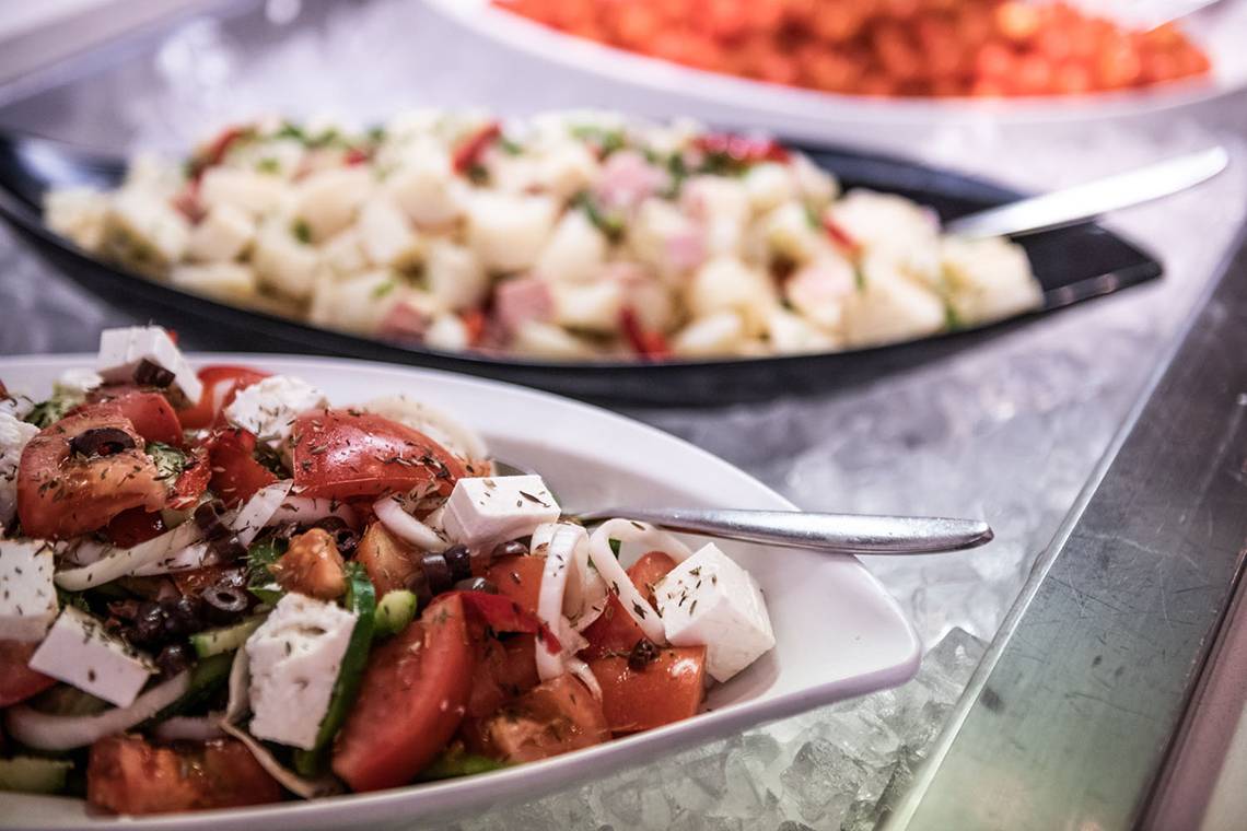 Foto von Salatbuffet im Avra Imperial Hotel mit verschiedenen Gerichten auf Eis.