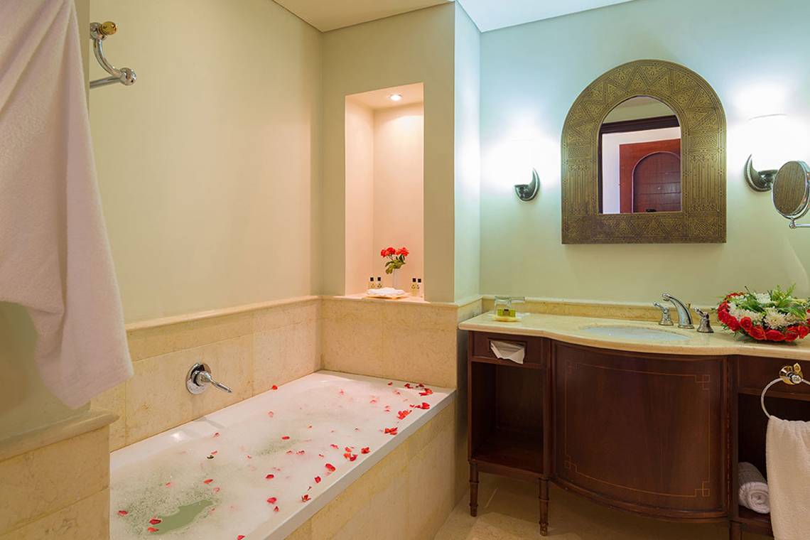 Badezimmer mit Badewanne und Blumendekoration im Pickalbatros The Palace Port Ghalib Hotel