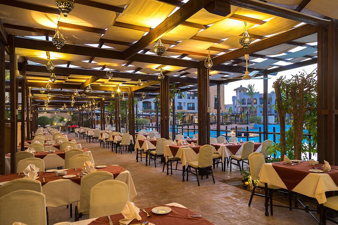 Restaurant im Pickalbatros The Palace Port Ghalib mit Tischen und Stühlen unter Pergolen