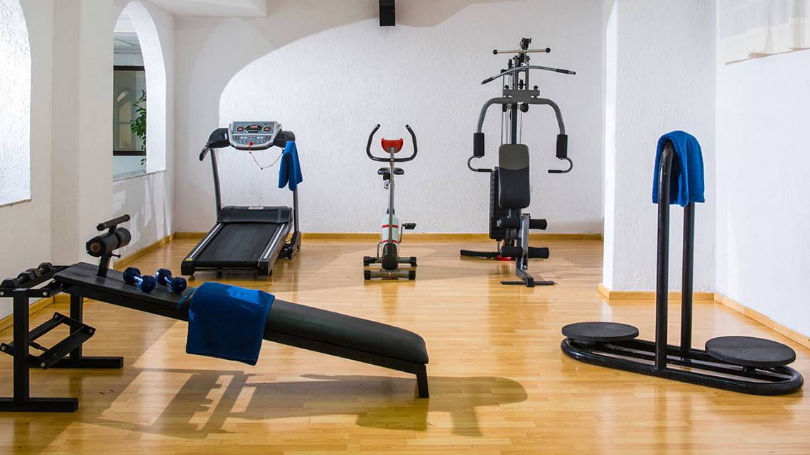 Fitnessraum im Hersonissos Palace Hotel mit Laufband, Hantelbank und anderen Geräten.