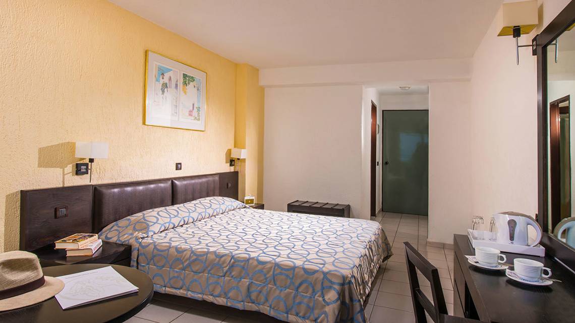 Innenansicht eines Hotelzimmers im Hersonissos Palace Hotel mit Bett, Schreibtisch und Teekanne