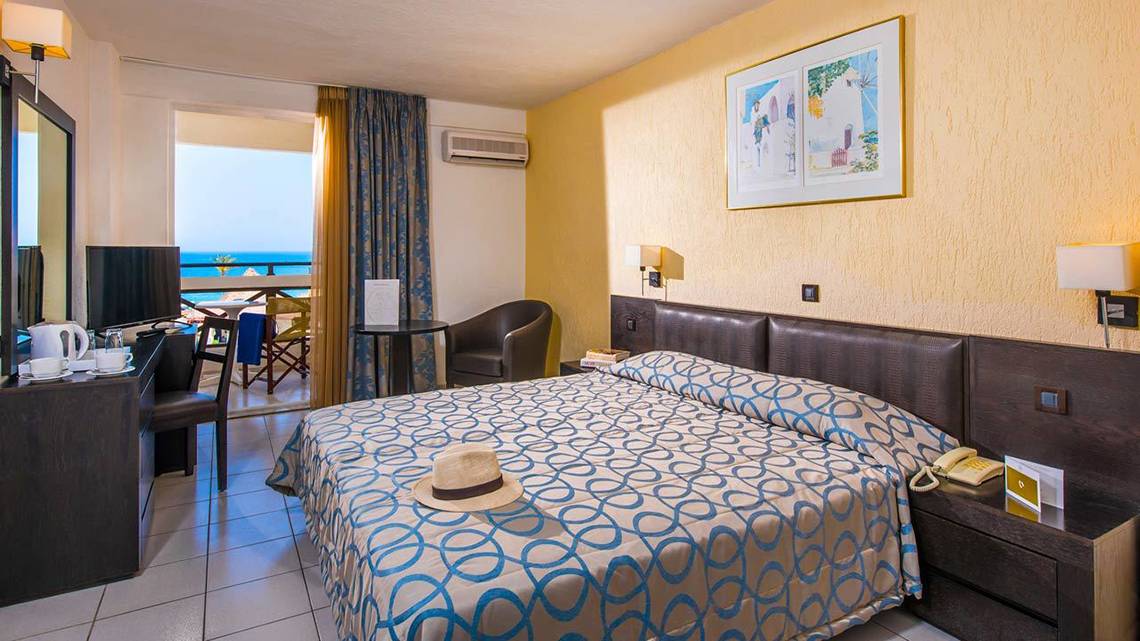 Ein Hotelzimmer im Hersonissos Palace mit Blick auf das Meer und moderne Einrichtung.