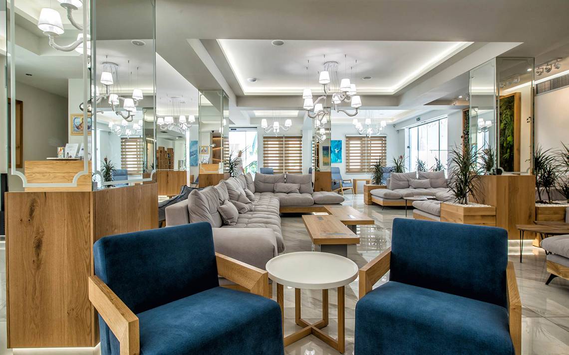 Lobby des Odyssia Beach Hotels mit modernen Möbeln, hellen Farben und großen Spiegeln.