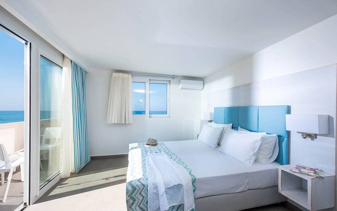 Ein modernes Zimmer im Odyssia Beach Hotel mit Blick auf das Meer und einer Terrasse.