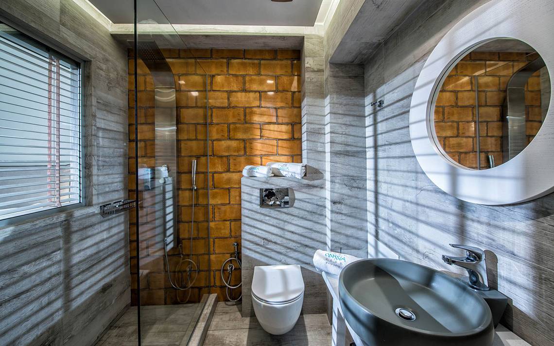 Badezimmer im Odyssia Beach Hotel mit Dusche, Toilette und Waschbecken.