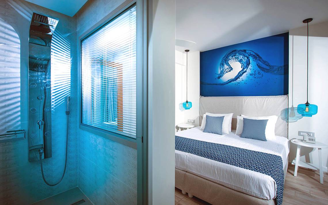 Schlafzimmer und Badezimmer im Odyssia Beach Hotel mit blauem Thema und modernen Möbeln.