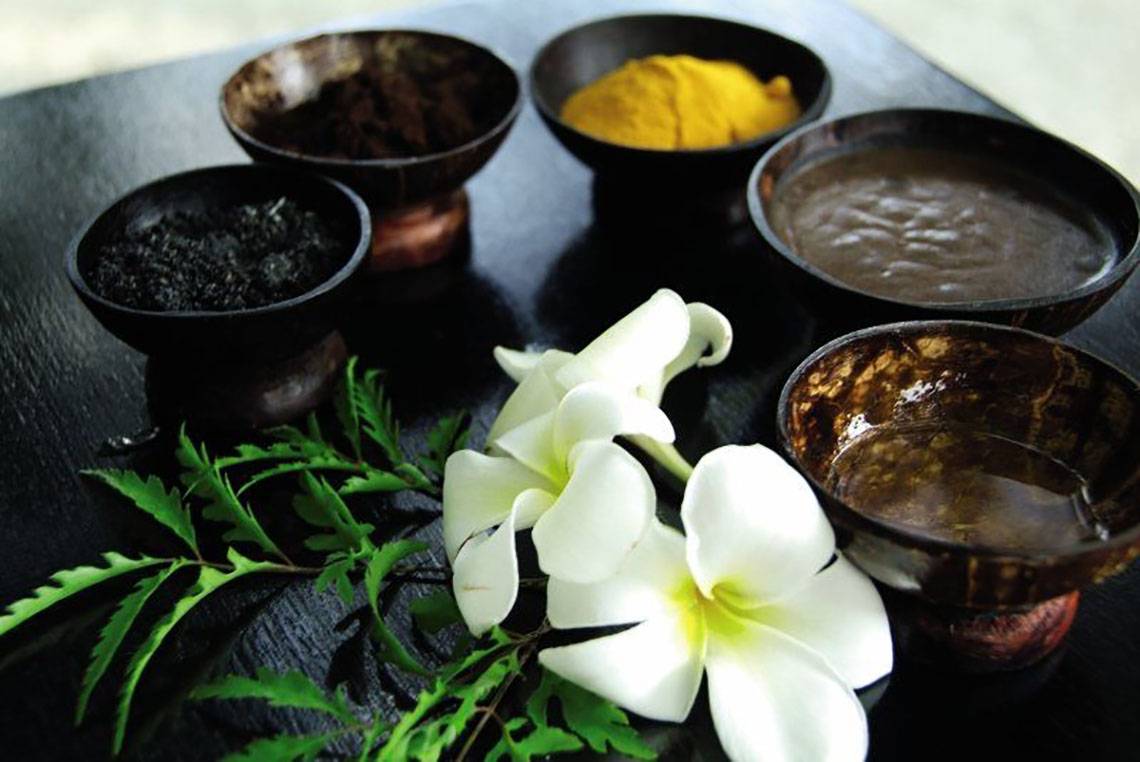 Spa-Produkte auf dem Biyadhoo Island Resort, darunter Blumen und verschiedene Paste.