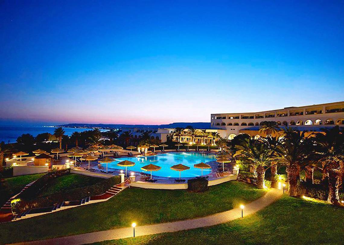 Abendaufnahme des Mitsis Norida Beach Hotels mit Swimmingpool und Meerblick.