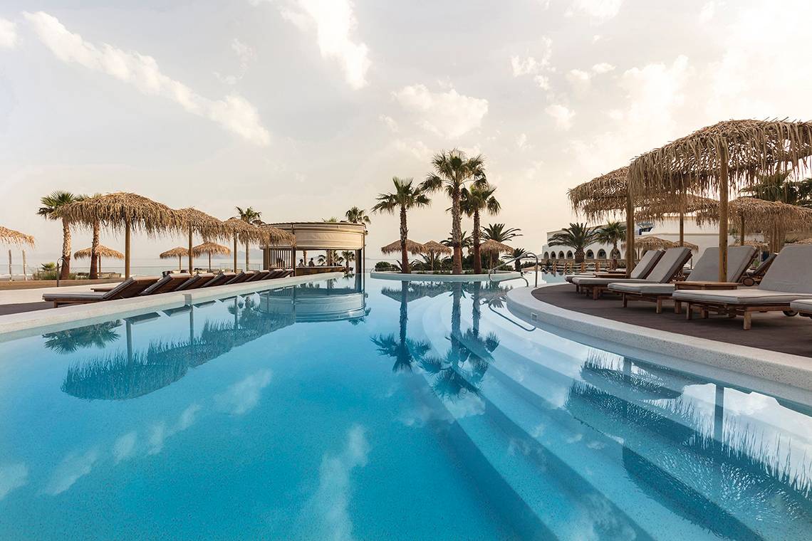 Außenpoolbereich des Mitsis Norida Beach Hotels mit Loungeliegen und Palmen