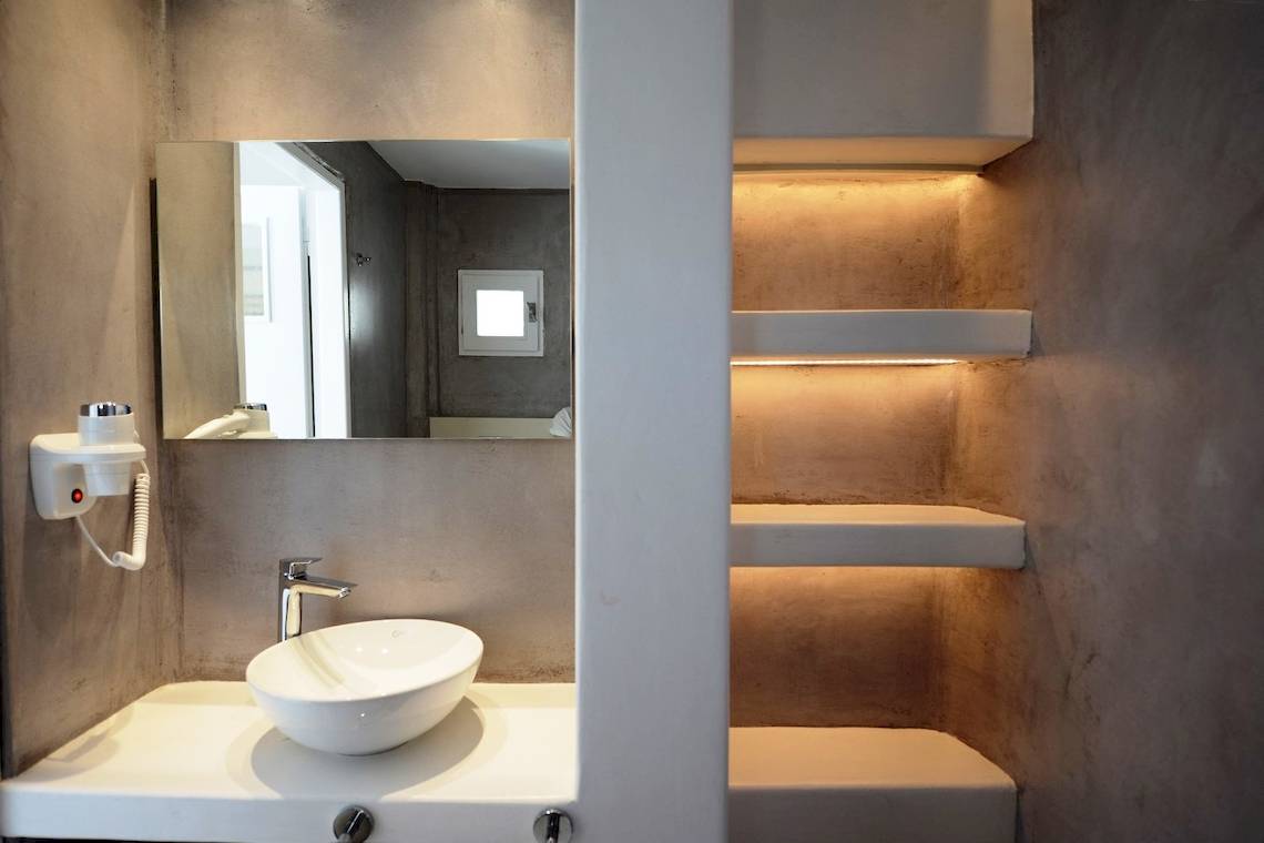 Badezimmer im MykonosView Hotel mit einem Spiegel und einem Waschbecken.