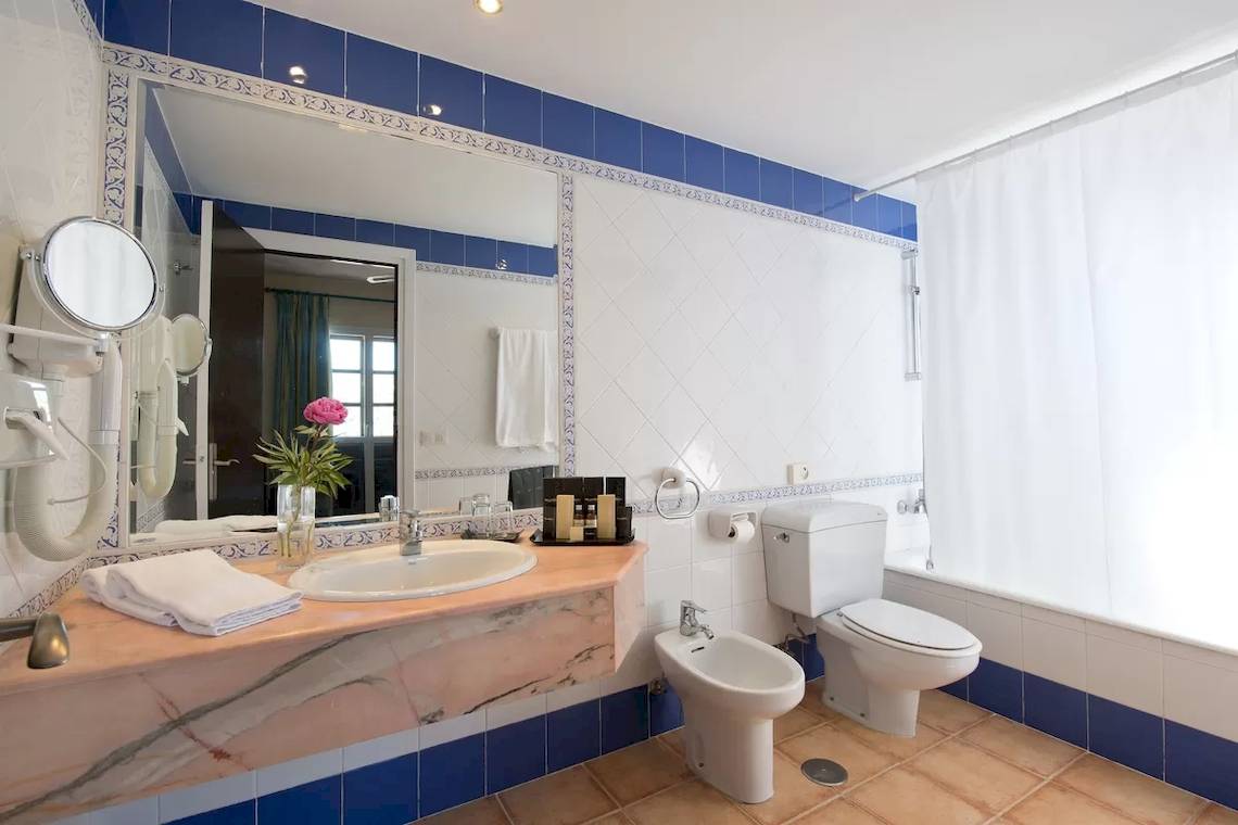 Badezimmer im Bluebay Banus Hotel mit Waschbecken, Bidet, Toilette und Badewanne.