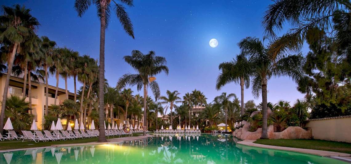 Der Pool des Bluebay Banus Hotels bei Nacht mit Vollmond und Palmen