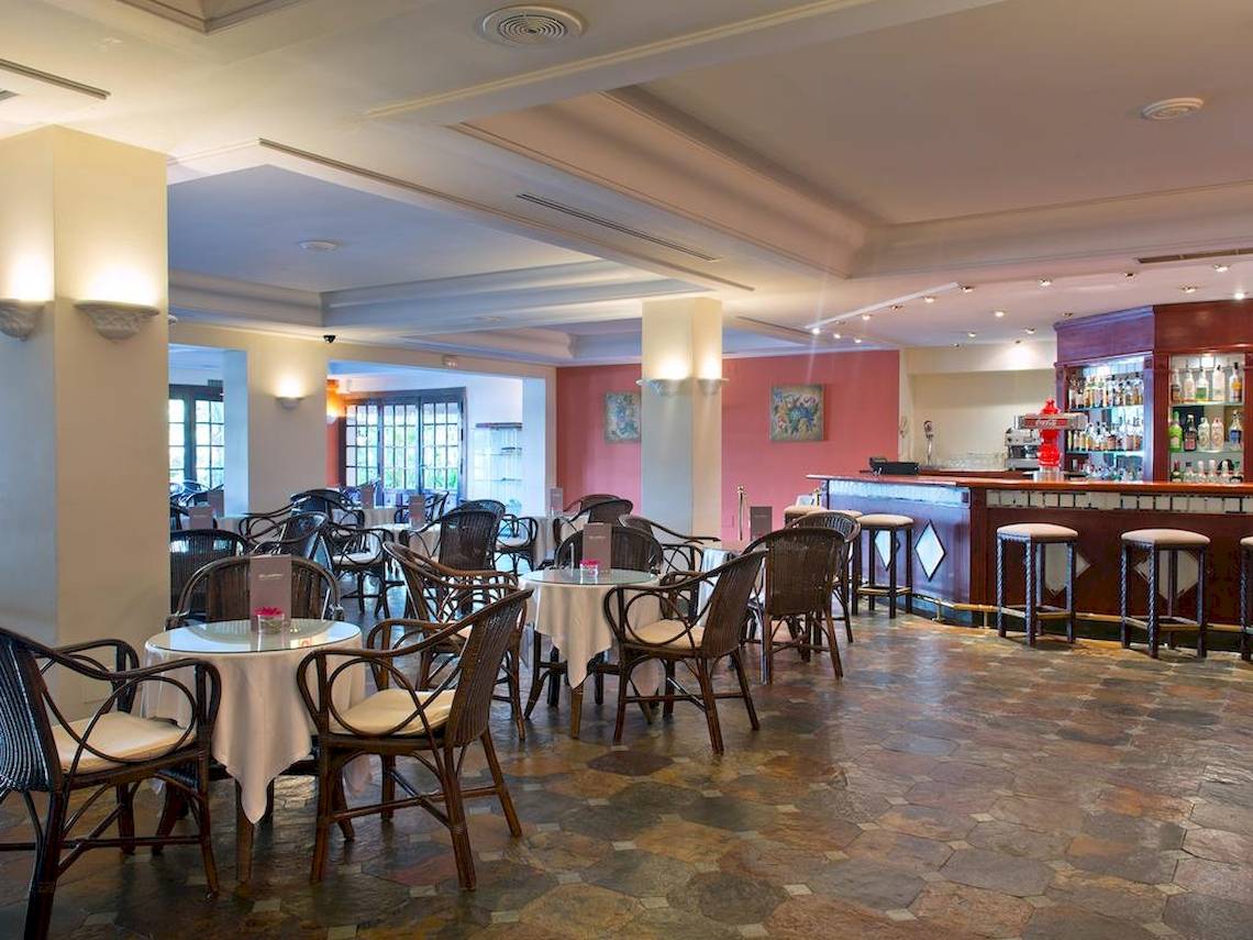 Innenansicht des Bluebay Banus Hotel Restaurants mit Tischen, Stühlen und einer Bar.