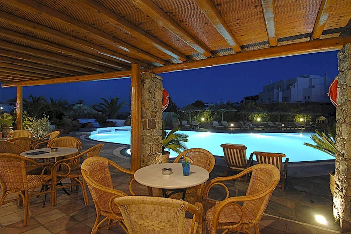 Außenterrasse des Kamari Hotels bei Nacht mit Blick auf den Pool und beleuchteten Gebäuden.