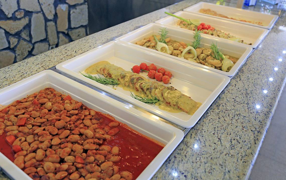 Mehrere weiße Speisentabletts auf einem Granittisch im LABRANDA Kiotari Miraluna Resort