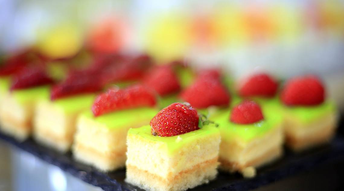 Foto von verschiedenen Desserts mit grüner und roter Glasur und Erdbeeren, serviert im LABRANDA Kiotari Miraluna Resort.