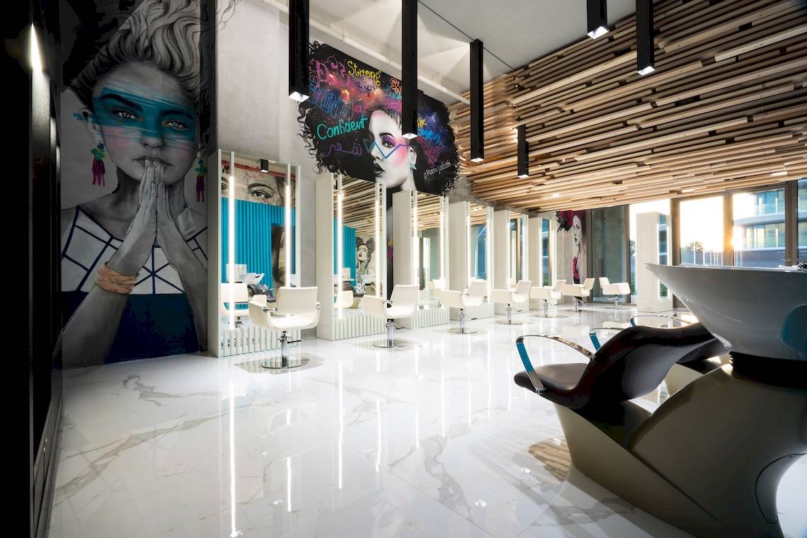 Innenansicht des Friseursalons im W Dubai - The Palm Hotel mit weißen Stühlen und Marmorboden.