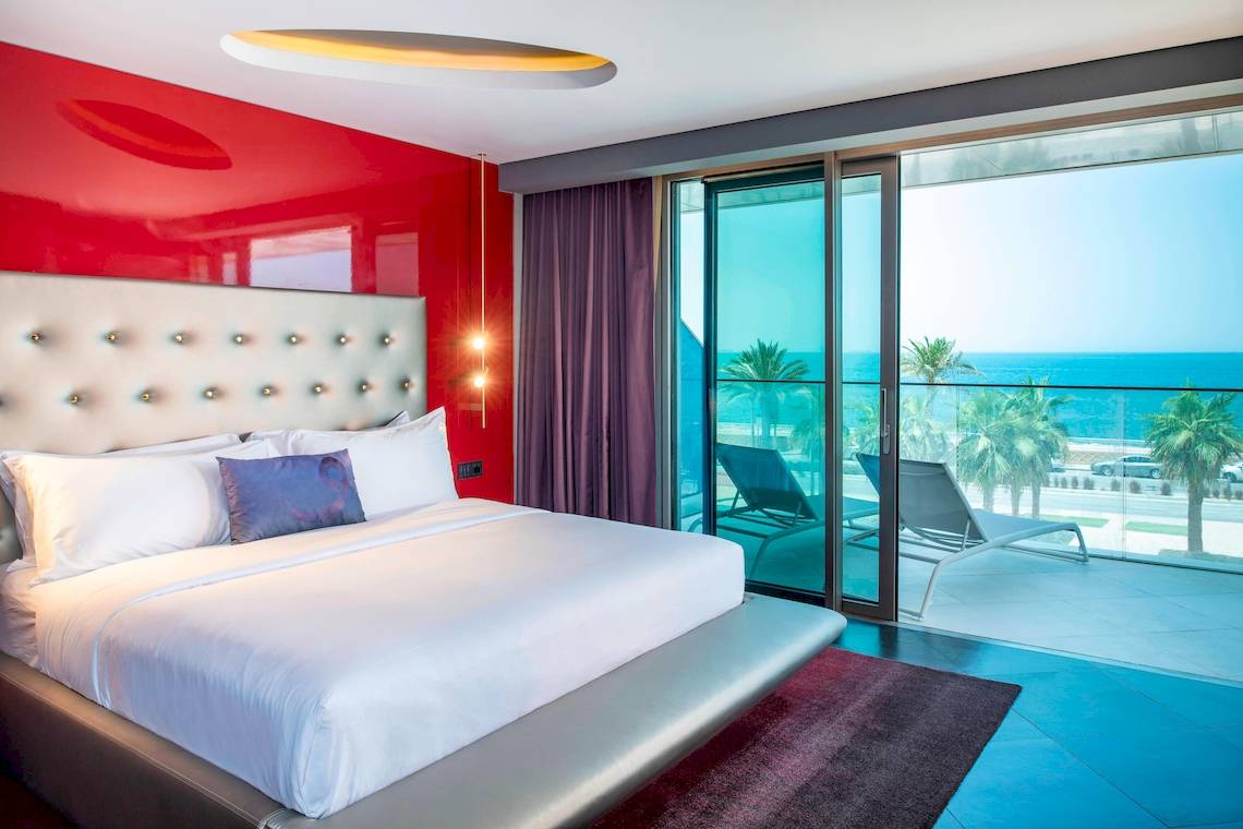 Zimmer im W Dubai - The Palm Hotel mit Blick auf das Meer von einem großen Bett aus gesehen