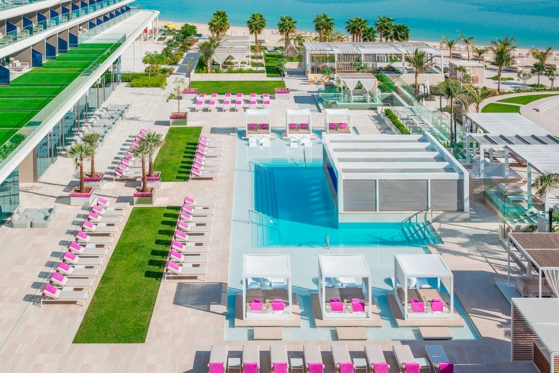 Luftaufnahme des W Dubai - The Palm Resorts mit Pool, Liegestühlen und Blick auf den Strand