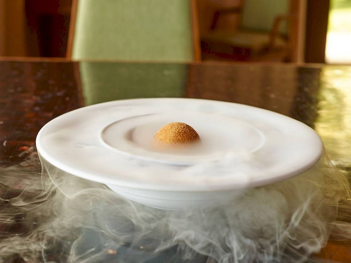 Ein weißer Teller mit rauchigen Effekten, auf dem ein Dessert serviert wird.