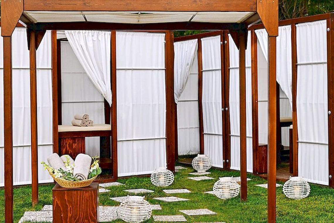 Spa-Bereich im Atlantica Akti Zeus Hotel mit Holzpavillon und weißen Vorhängen.