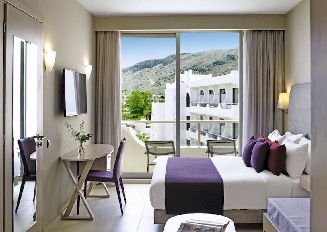 Innenansicht eines Zimmers im Atlantica Akti Zeus Hotel mit Blick auf die Berge.