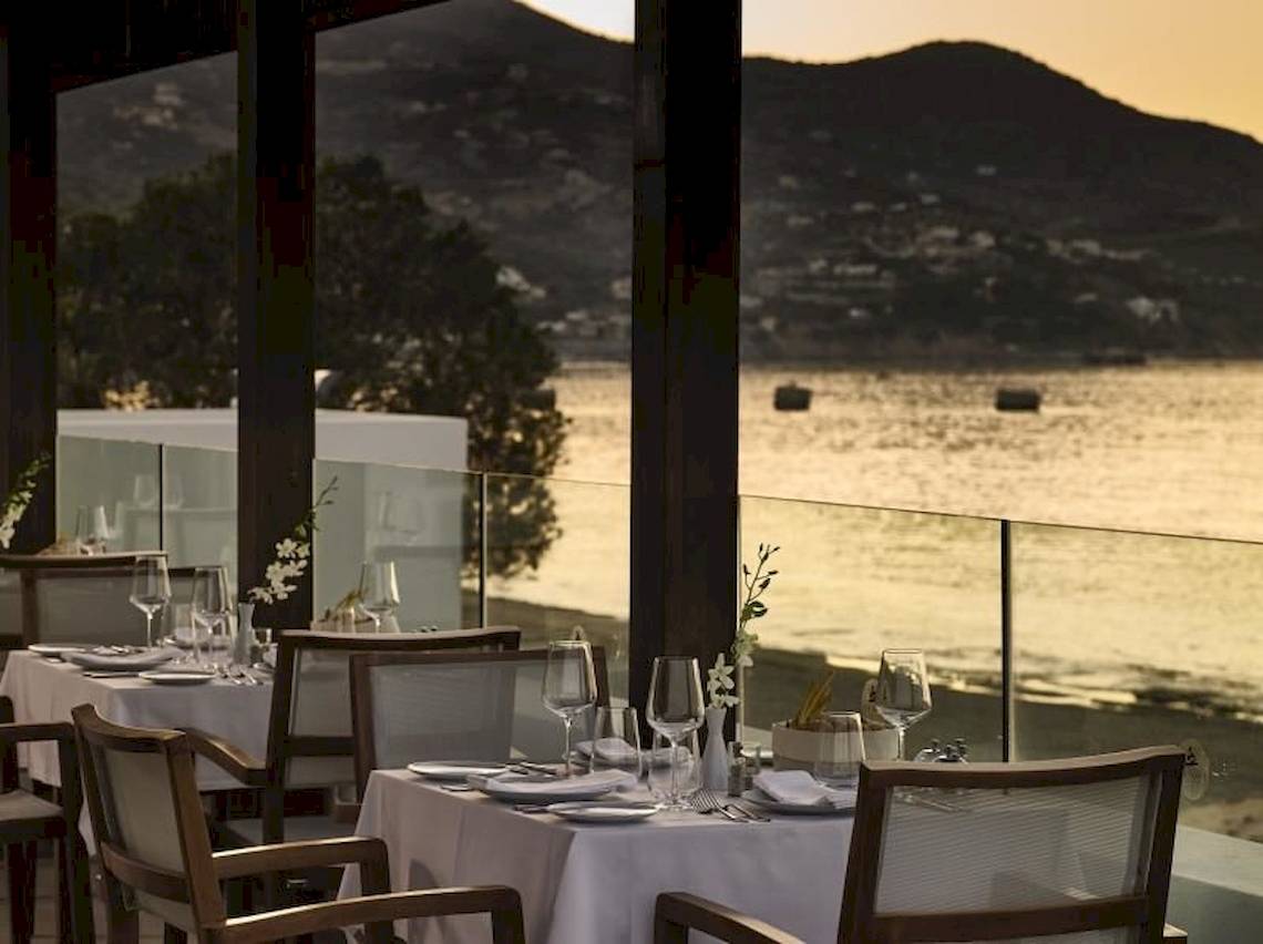 Restaurant mit Meerblick im Atlantica Akti Zeus Hotel, Tische und Stühle sind draußen aufgestellt.