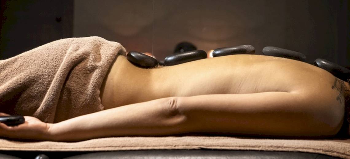Eine Person im Lagomandra Beach Hotel genießt eine Massage mit heißen Steinen.