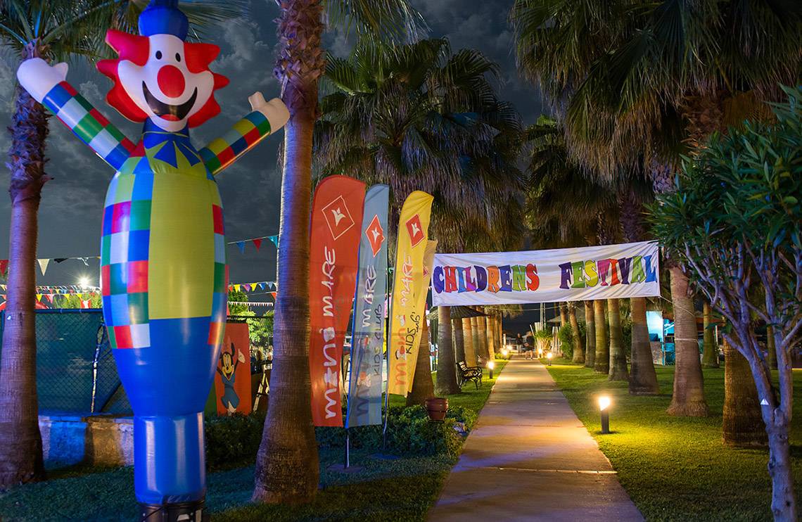Eingang zum Kinderfestival mit einer großen Clown-Aufblasfigur und bunten Bannern.