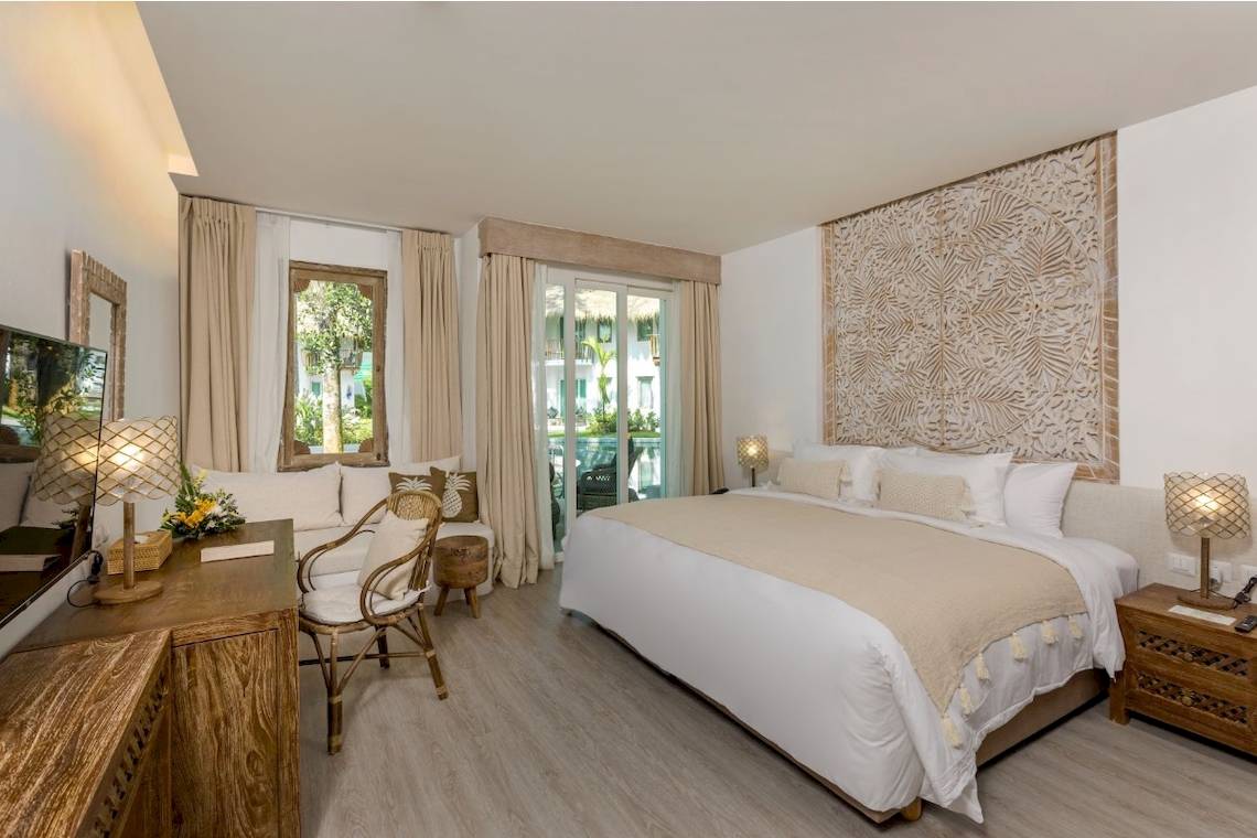 Schlafzimmer im Eden Beach Khao Lak Resort & Spa mit Balkon und Gartenblick