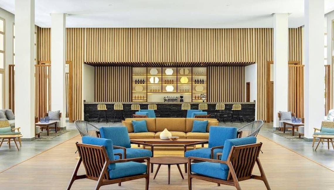 Lobby des Jaz Maraya Resorts mit blauen Stühlen und einem braunen Sofa.