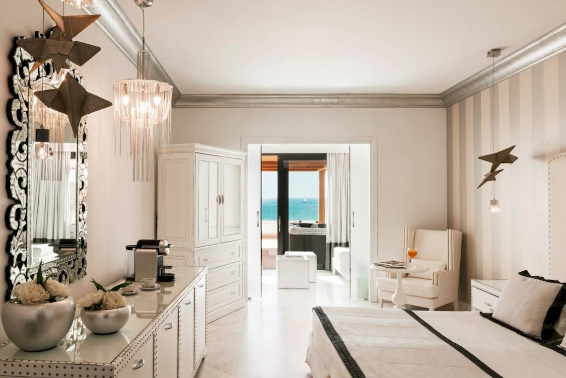 Schlafzimmer im Mitsis Alila Resort & Spa mit Blick auf das Meer und modernen Möbeln.