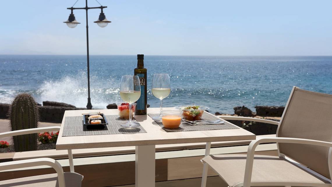 Tisch mit Getränken und Essen auf einer Terrasse mit Meerblick im Iberostar Selection Lanzarote Park