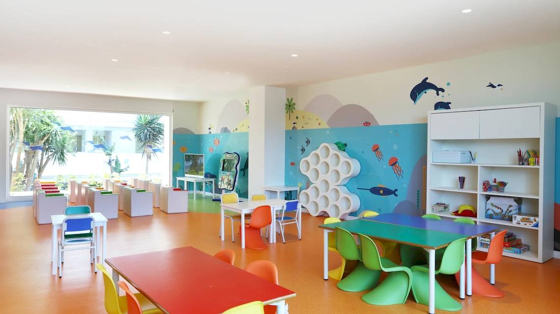 Farbig gestaltetes Kinderzimmer im Iberostar Selection Lanzarote Park Hotel mit bunten Tischen und Stühlen.