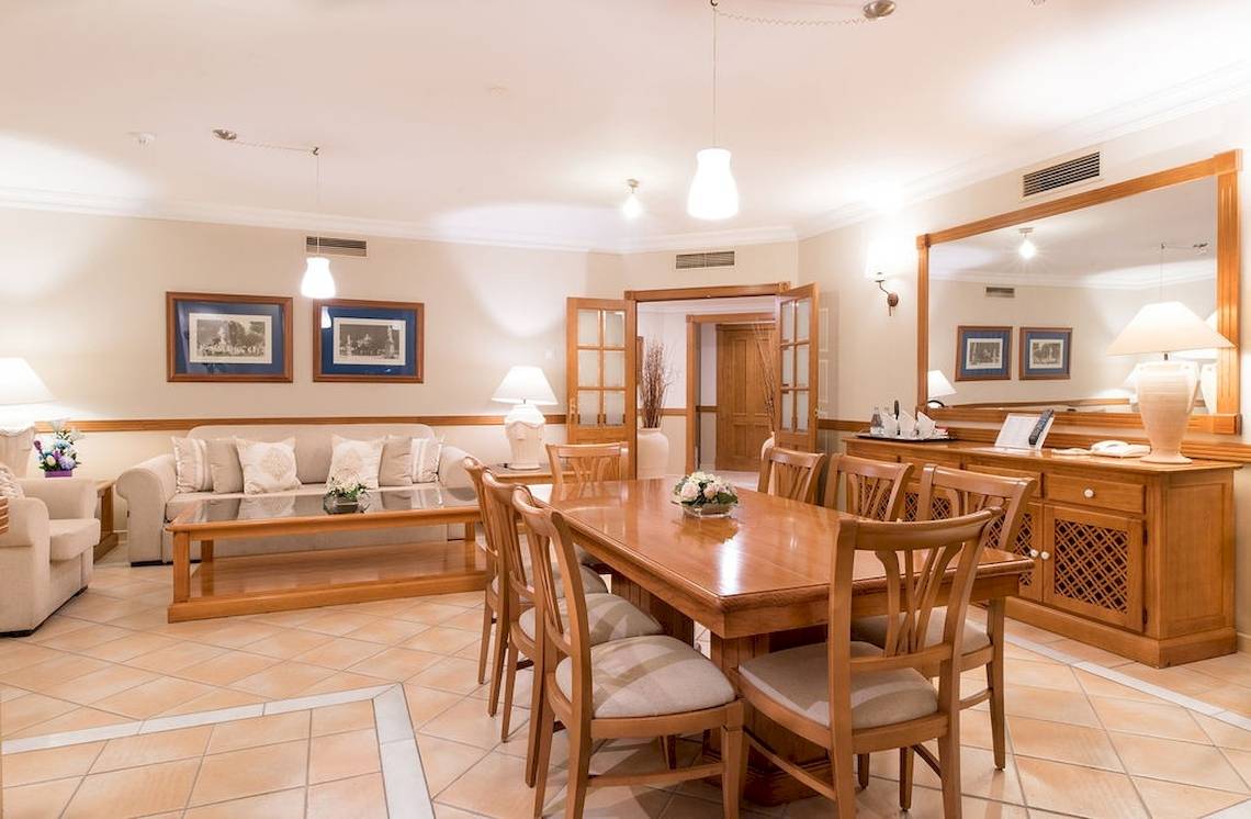 Speisezimmer im GF Gran Costa Adeje Hotel mit Esstisch, Stühlen und Dekor.