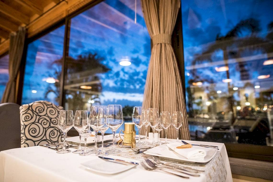 Ein Restauranttisch im GF Gran Costa Adeje mit leeren Gläsern und Besteck, draußen ist es Nacht.