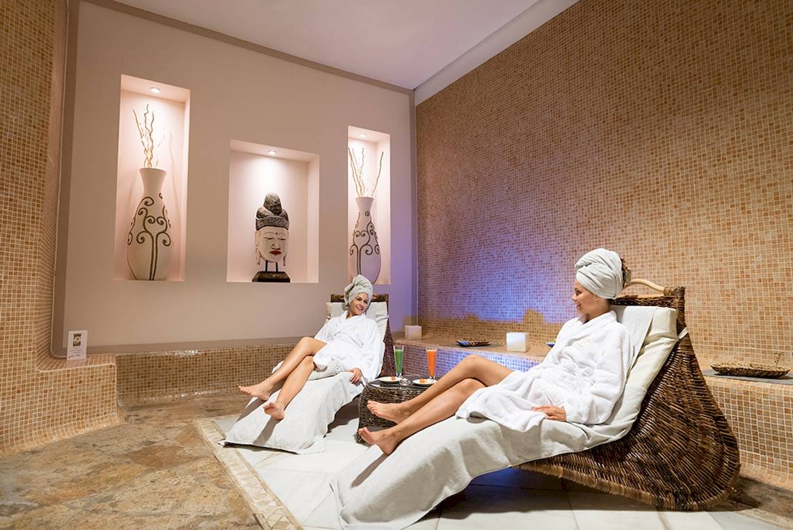 Spa-Bereich im GF Gran Costa Adeje Hotel mit zwei Frauen in weißen Bademänteln, die sich entspannen.