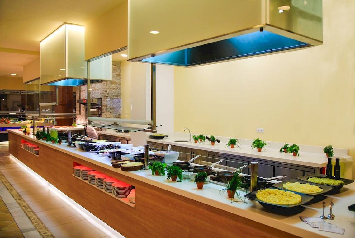 Buffetbereich im GF Gran Costa Adeje Hotel mit verschiedenen Gerichten und Pflanzendekoration.