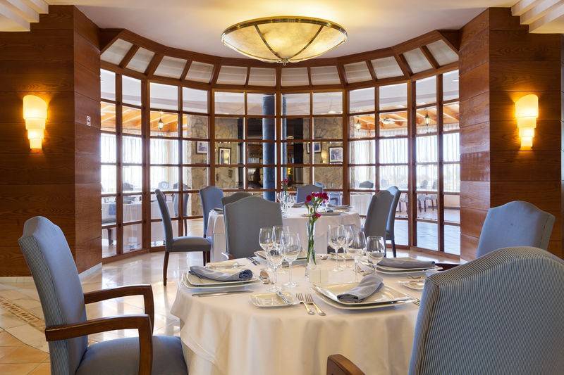 Innenansicht des Restaurants im GF Gran Costa Adeje mit gedeckten Tischen und Blumenarrangement.