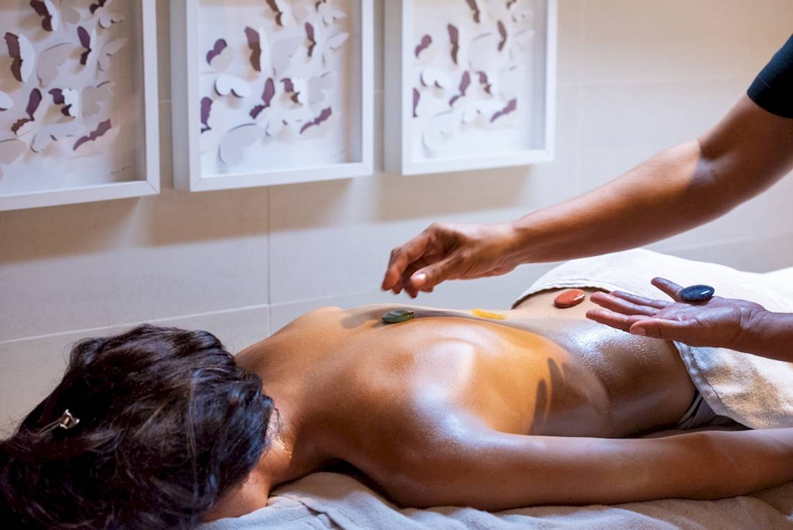 Eine Frau erhält eine Massage mit Steinen im GF Gran Costa Adeje Hotel.