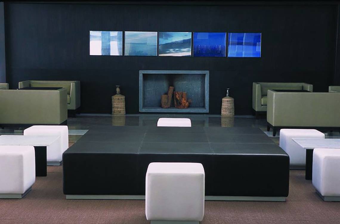 Lobby-Lounge-Bereich des Almyra Hotels mit modernen Möbeln, zentralem Tisch und Kunstwerken.