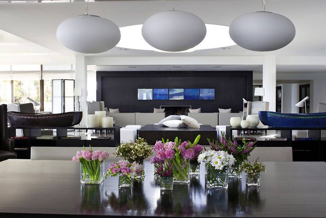 Wohnzimmer im Almyra Hotel mit Blumen auf dem Tisch und runden Lampen.