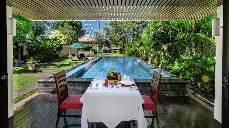 Außenesstisch am Pool im Prama Sanur Beach Bali Hotel mit Blick auf den Garten