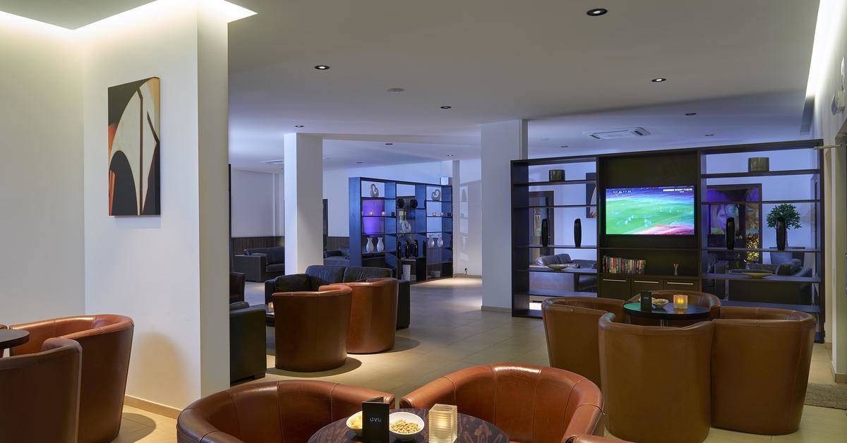 Loungebereich des Melia Dunas Beach Resort mit Fernseher und Lederstühlen.