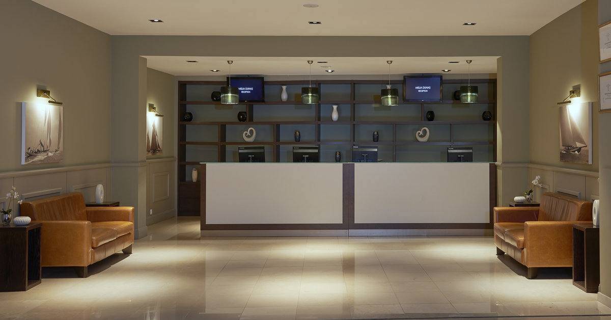 Empfangsbereich des Melia Dunas Beach Resort & Spa mit hellem Interieur und modernen Möbeln.