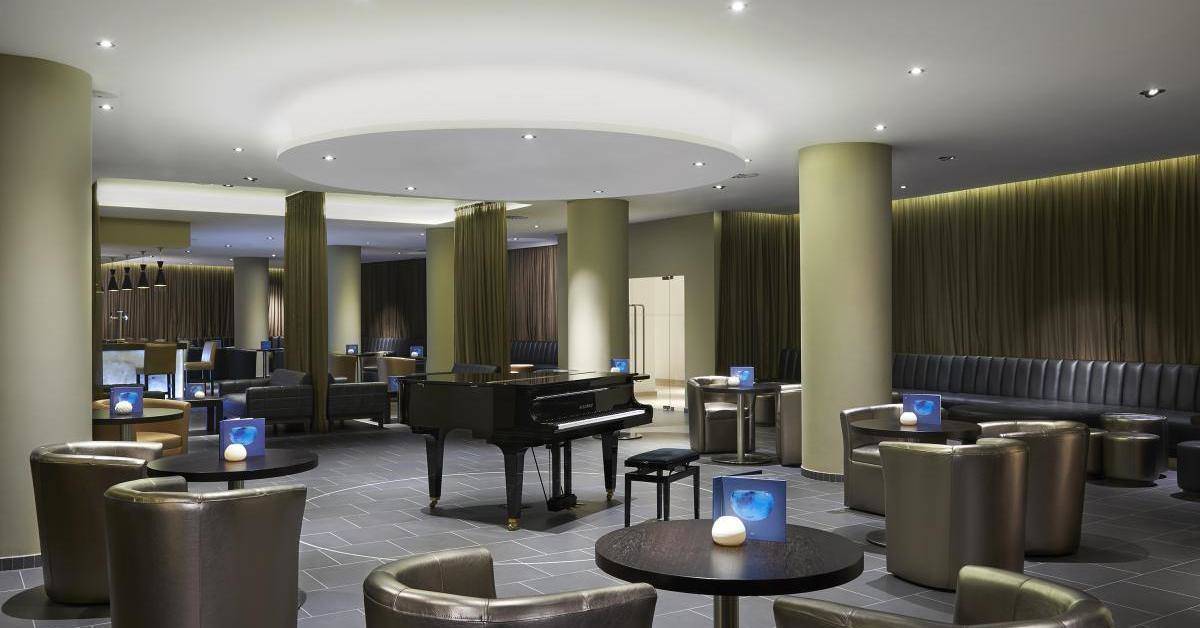 Loungebereich des Melia Dunas Beach Resort mit Klavier und Lederstühlen.
